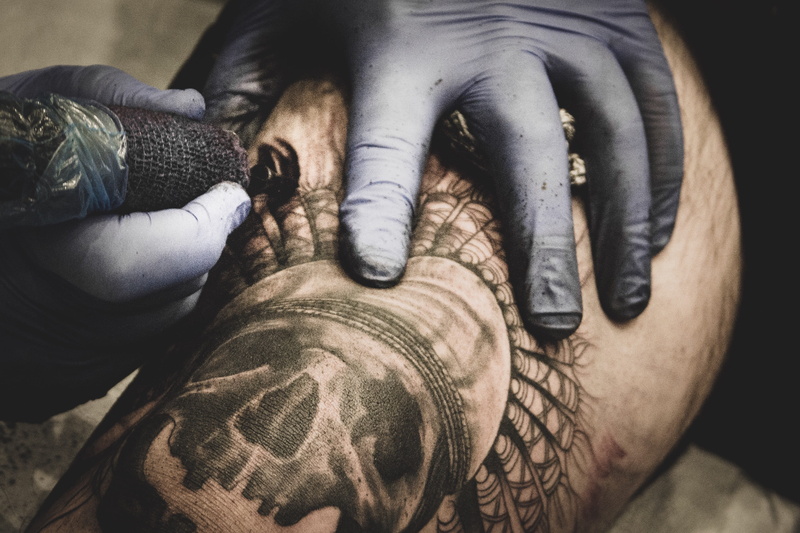 arm, tattooist, indoors, skin, skull, artist, protective workwear, real people, daytime, tattoo, adult, glove, one person, protective glove, tattooing