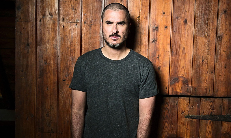 t, zane lowe, looking at camera, real people, dj, black color, casual clothing, entrance, contemplation, wood - material, standing, portrait, musician