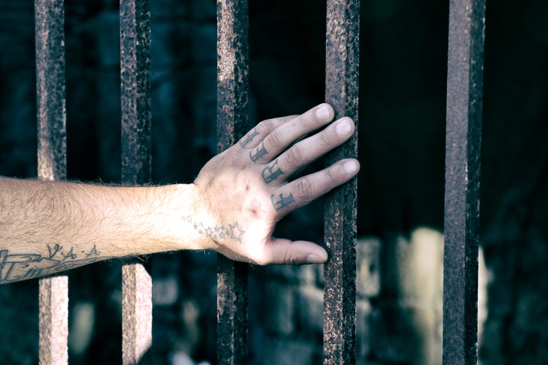 one person, prison cell, finger, real people, bars, men, human hand, italy, building, tatoo, security bar, human body part, crime, human limb, prison, prison bars