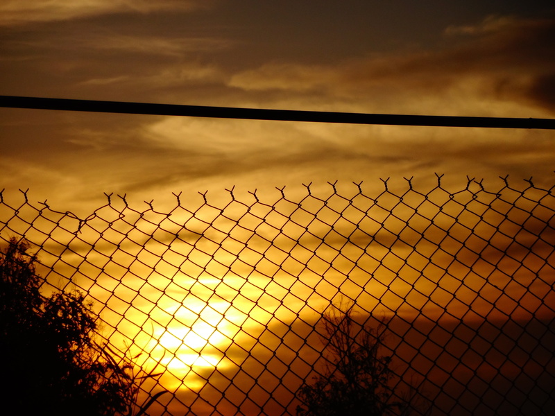 nature, wire, orange, prison, clouds, sunset, exclusion, silhouette, steel, sunlight, dark clouds, wire mesh, building, sun, boundary, cloud - sky, alloy