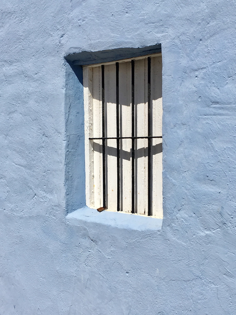 east, no people, metal, geometric shape, security bar, building, built structure, punishment, grid, day, white color, wall - building feature, sunlight