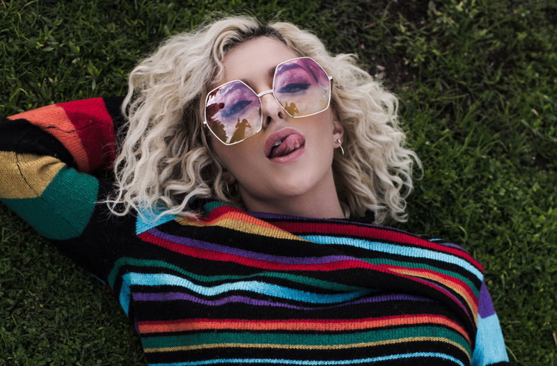 tongue out, sweater, glasses, green background, women with glasses, earring, pierced ear, looking at viewer, 1080P, blonde, colorful, lying on back, women