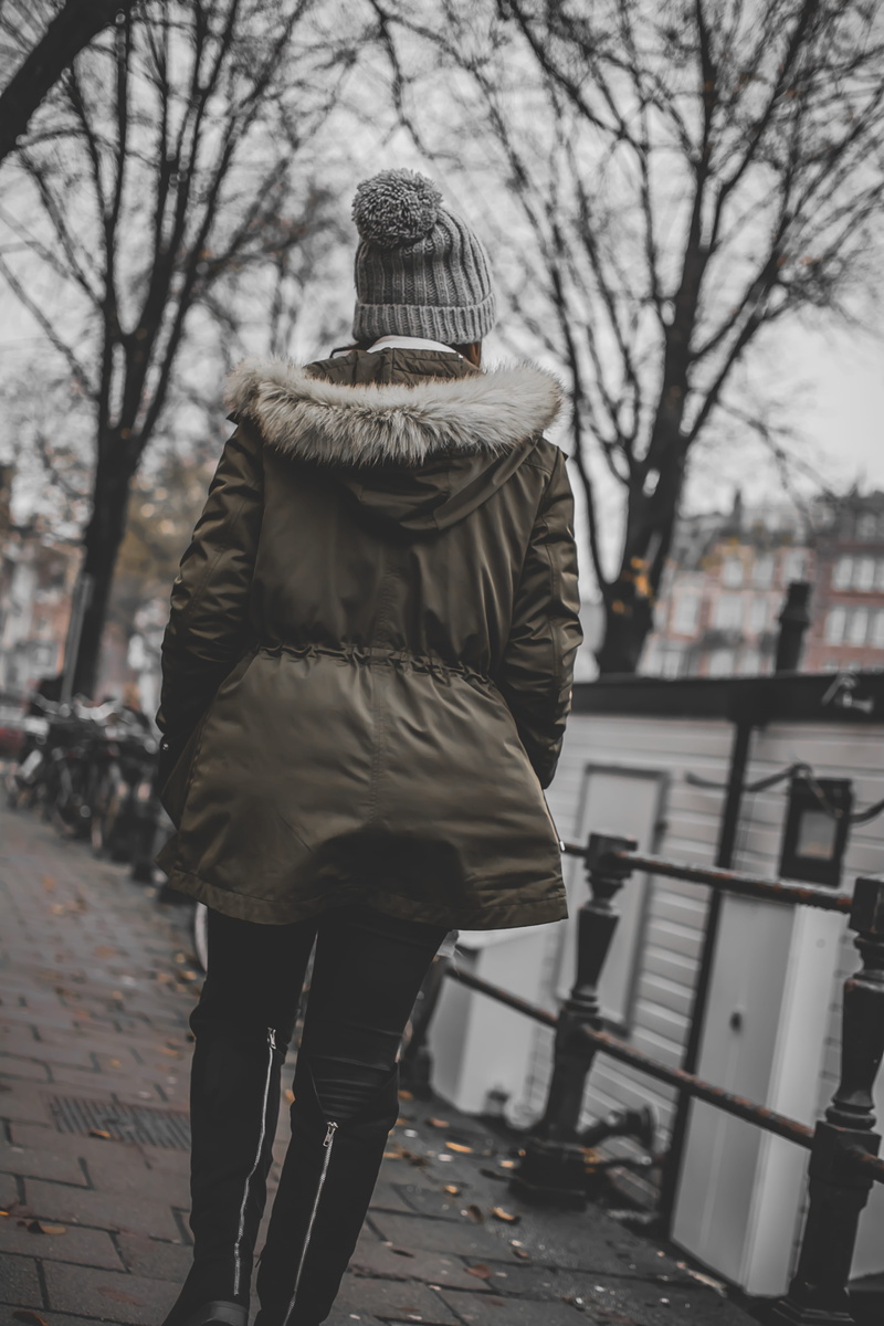 warm clothing, clothing, walk, female, hat, standing, real people, bare tree, architecture, city, cold temperature, one person, walking, lifestyles, winter coat
