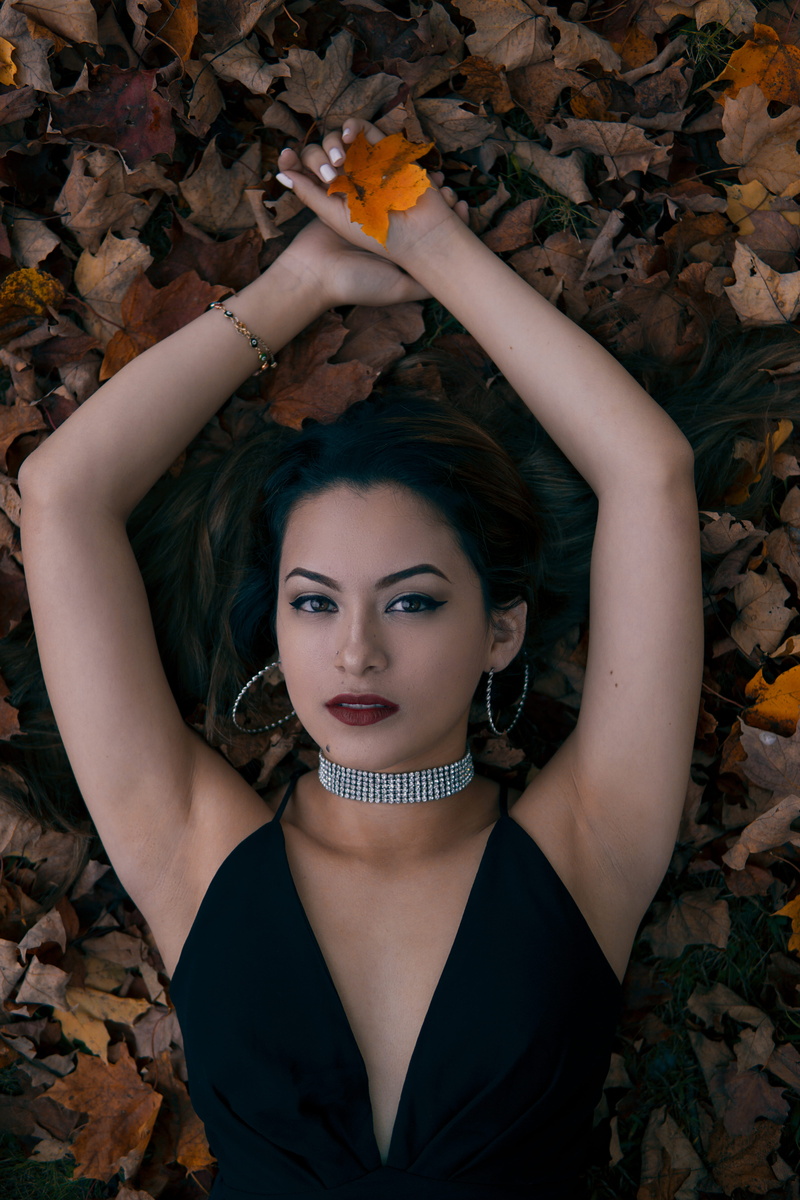 necklace, wear, female, elegant, eyes, jewelry, leaves, lying down, bracelet, pose, person, hands, lying, real people, face, earing, arms, holding, young adult