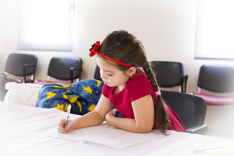 flower, study, studying, lying down, sitting, dress, pen, holding, red, females, furniture, women, hairdo, table, chairs, concentration, paper, girls, headband