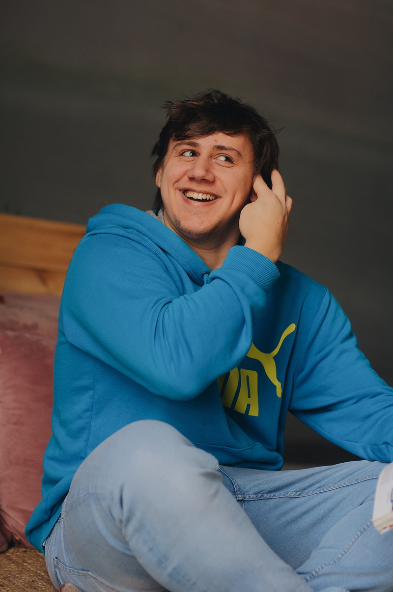 brown, clothing, indoors, smiling, furniture, sitting, puma, blue, wood, emotion, one person, casual clothing, lifestyles, 4K, hoodie, russia, man, three quarter length