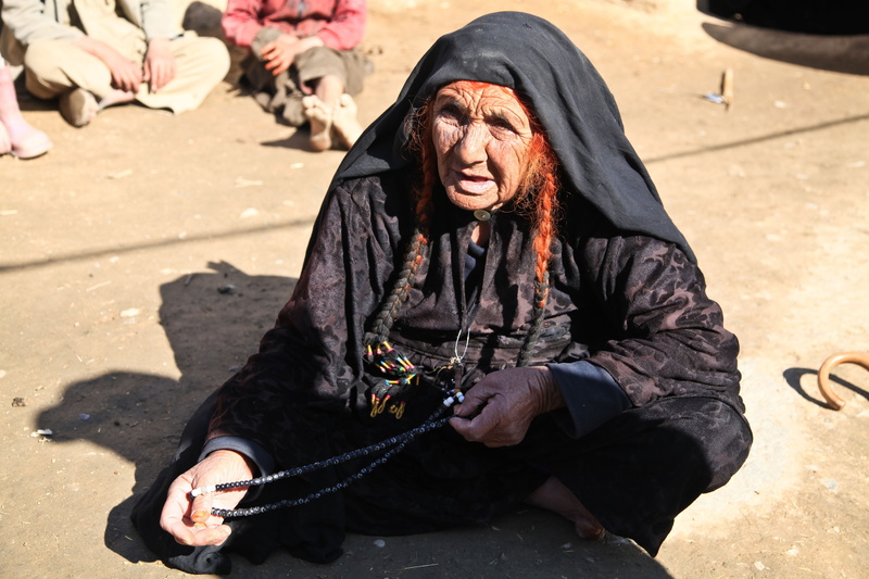 sitting, wrinkled, person, one person, muslim, leisure activity, street, casual clothing, beggar woman, farmland, woman, long hair, beggar, day, afghanistan