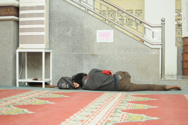 lifestyles, text, relaxation, carpet - decor, one person, young adult, sleeping, architecture, indoors, day, beggars, sleep, floor, tired, sadness, lying down