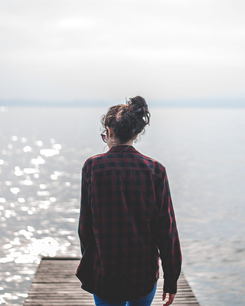 non-urban scene, one person, looking at view, outdoors, lake, hairstyle, beauty in nature, lifestyles, casual clothing, 2K, real people, fashion, dress