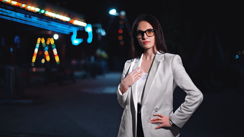 white jacket, women with glasses, lifestyles, illuminated, depth of field, blouses, looking at viewer, standing, lights, nightlife, looking, women outdoors