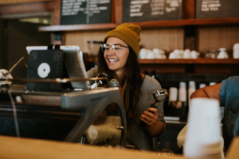 real people, adult, coffee, small business, beautiful woman, chalkboard, smiling, emotion, machine, holding, indoors, person, young adult, setting, young women
