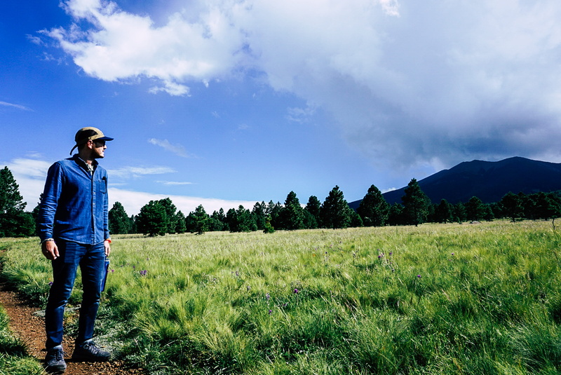 cloud - sky, young adult, real people, leisure activity, non-urban scene, plant, jeans, scenics - nature, nature, grass, casual clothing, flagstaff, standing