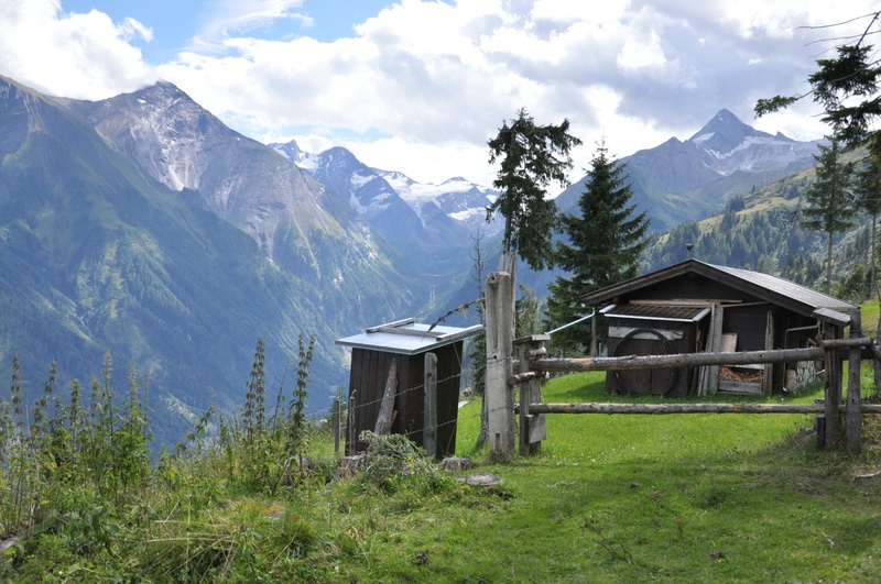 sky, mountain peak, built structure, plant, austria, grass, outdoors, landscape, shanty, building exterior, alps, day, architecture, green color, snowcapped mountain