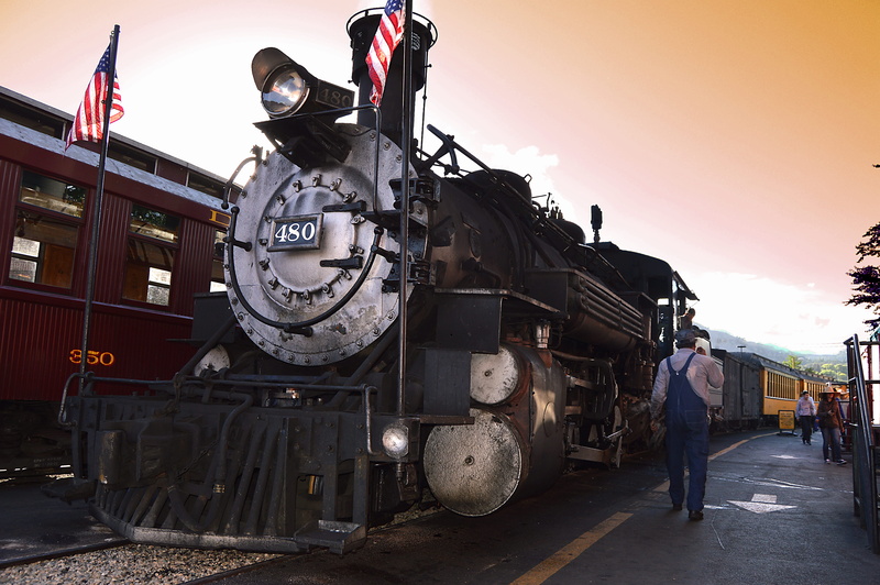 real people, land vehicle, american flag, station, locomotora, sky, walking, man, technology, day, steam train, architecture, sunlight, beside, people