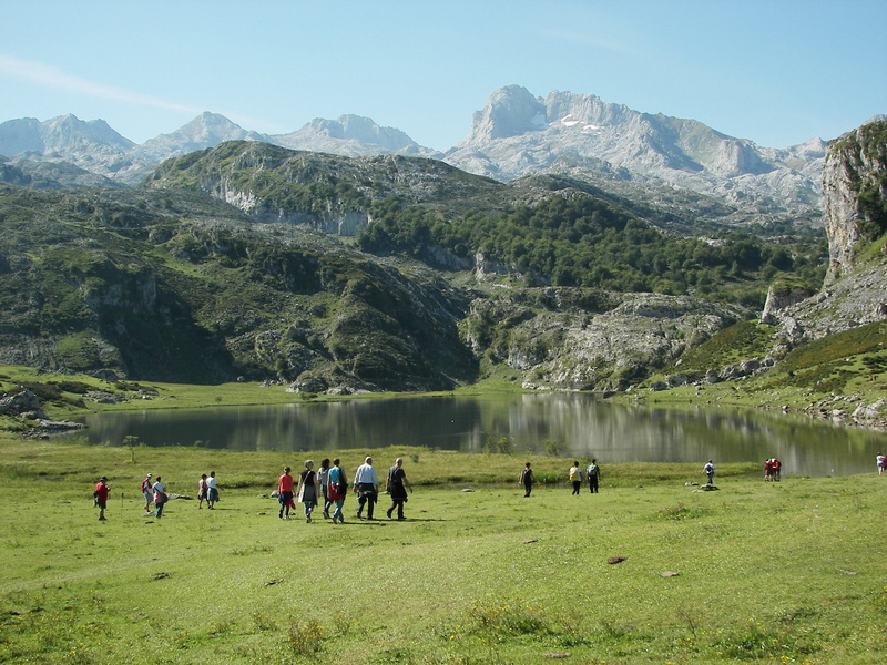 mountain range, clouds, outdoors, landscape, green, green color, non-urban scene, mountains, beauty in nature, environment, men, lake, grass, large group of people