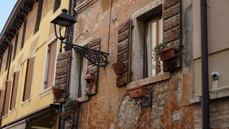 street, building, low angle view, apartment, built structure, day, wall, wall - building feature, history, lighting equipment, garda, italy, window, residential district