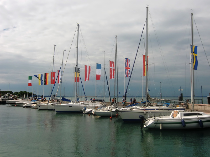 sailboat, moored, mode of transportation, pole, waterfront, water, flag, mast, outdoors, nature, day, harbor, no people, garda, italy, transportation, holiday