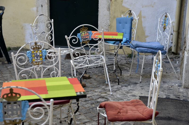 day, cafe, no people, seats, outdoors, seat, lisboa, wheel, empty, metal, building, table, bicycle, equipment, messy, seating arrangement, wall - building feature