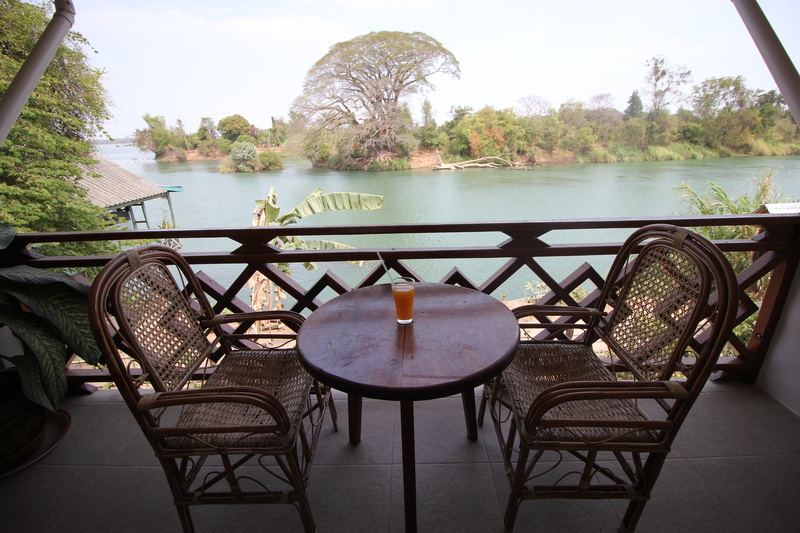 orange juice, asia, drink, swimming pool, si phan don, balcony, tree, day, chair, guesthouse, restaurant, table, brown, don det, no people, seat, absence