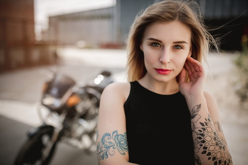 Yamaha, touching face, casual clothing, tattoo, one person, women, focus on foreground, hair, blonde, standing, looking at viewer, beauty, portrait, fashion