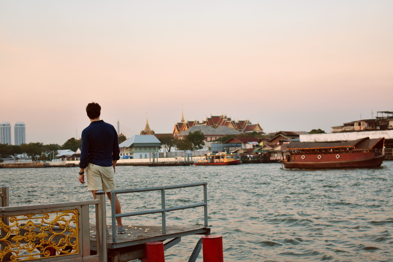river, sunset, transportation, rear view, building exterior, sea, 5K, lifestyles, tour, nautical vessel, temple, male, leisure activity, wat phrakaew
