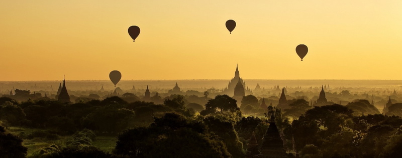sunset, place of worship, tree, sun, sky, outdoors, belief, forest, temple, hot air balloons, built structure, no people, balloon, nature, the past, panoramas