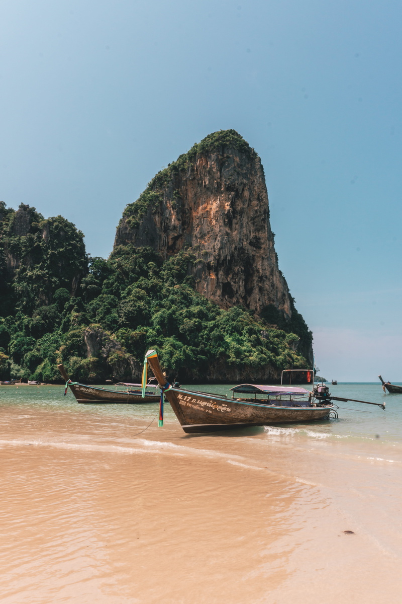 mountain, longtail boat, mode of transportation, beach, nature, scenics - nature, rock, rock formation, sand, tranquility, sea, outdoors, clear sky, thailand