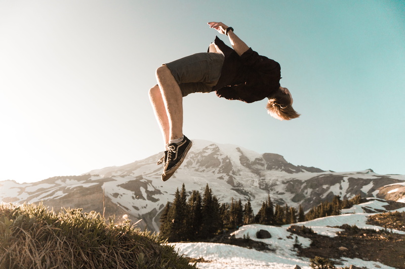 sunlight, sport, mid-air, holiday, jumping, mountain, cliff, sky, vacations, full length, leisure activity, day, back, adventure, man, beauty in nature