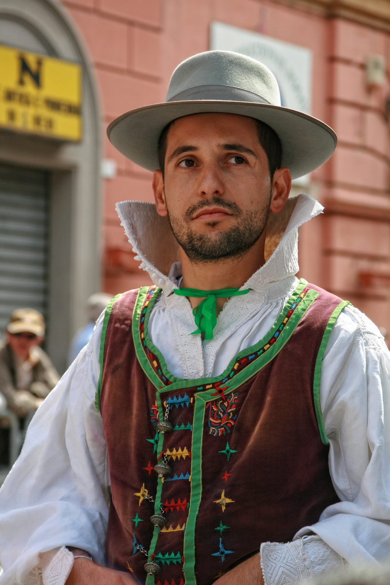 front view, focus on foreground, young adult, one person, architecture, italy, cagliari, men, looking at camera, beard, outdoors, traditional clothing