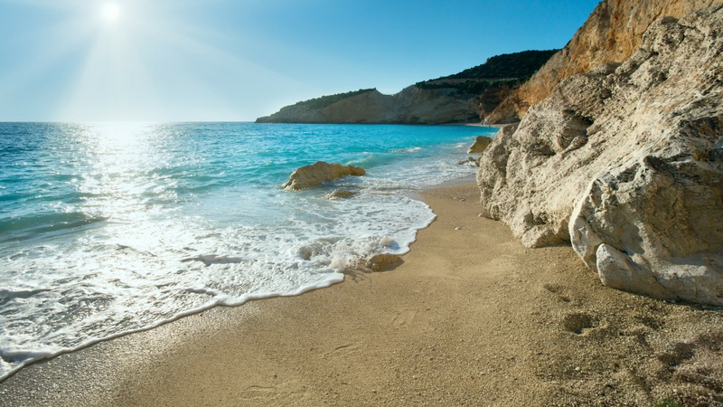 sunlight, blue sky, blue sea, ionian sea, rock, sunshine, outdoors, sand, beauty in nature, sea, no people, water, coast, beach, horizon over water, nature