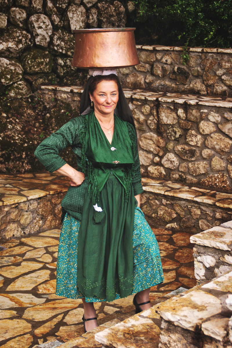 women, folk costume, portrait, clothing, greek, leisure activity, real people, front view, smiling, standing, culture, full length, traditional, stone wall