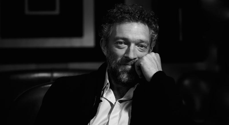 sitting, males, actor, indoors, facial hair, beard, 5K, Vincent Cassel, front view, young men, lifestyles, one person, headshot, well-dressed, focus on foreground