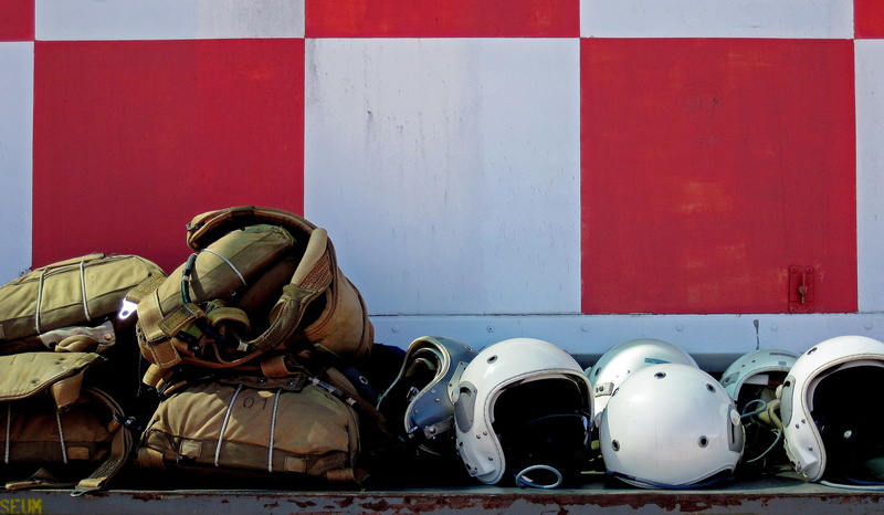 headwear, aviator, Bone, army, military, container wall, checkered, backpack, red, helmet, day, real people, pre-flight, pilot, wall - building feature