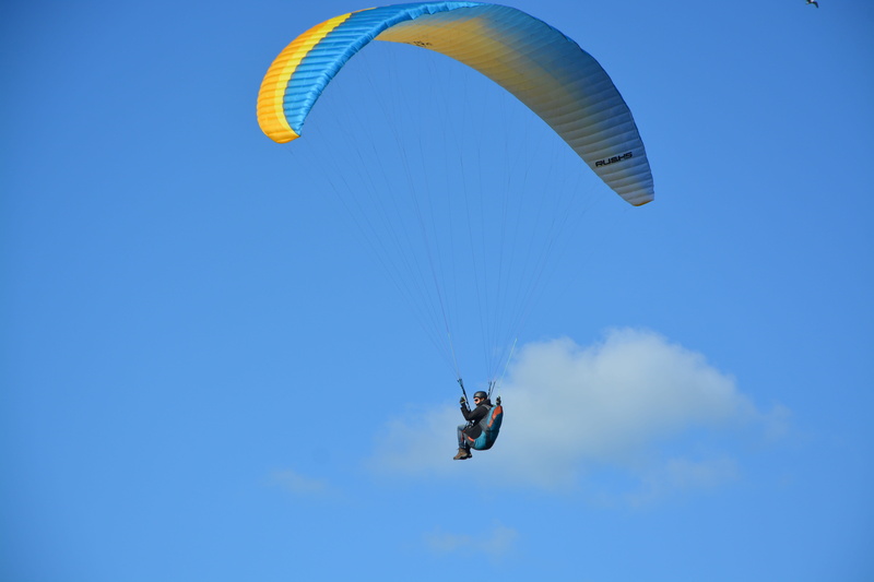 flying, low angle view, one person, fly, cloudy blue sky, mid-air, sport, joy, leisure activity, exhilaration, extreme sports, paragliding, sky, unrecognizable person