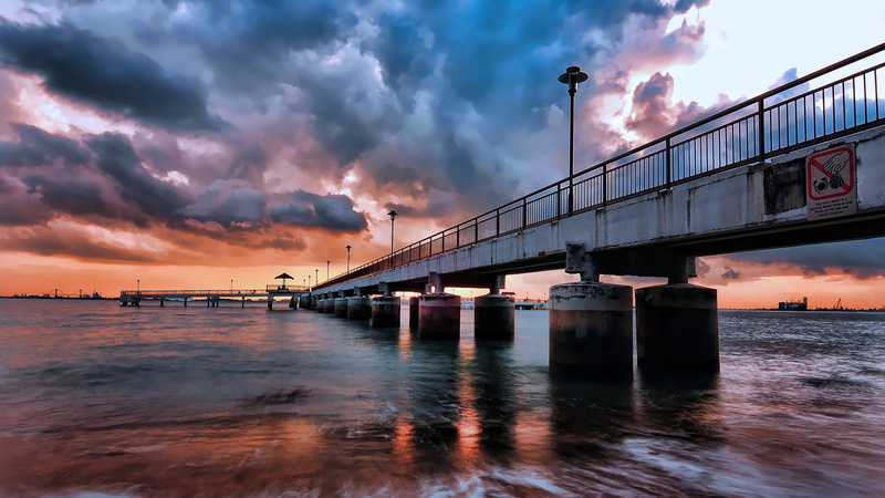 landmark, sea, orange color, cityscape, built structure, cloud - sky, connection, landscape, sunset, ocean, town, no people, marina, skyline, transportation