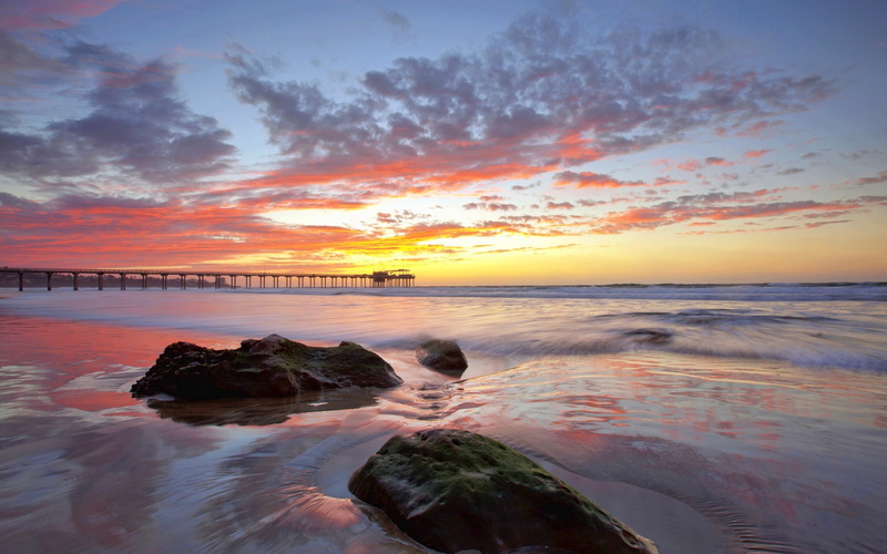 water, beauty in nature, sunset, sunlight, sea, rock - object, pier, sky, idyllic, beach, solid, golden, orange color, outdoors, tranquil scene, hour, land