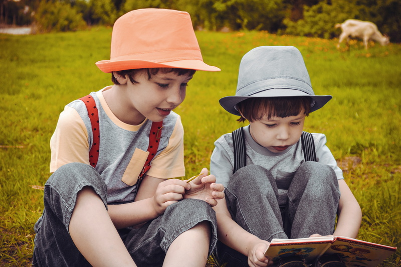 brother, outdoors, males, innocence, family, large, forest, offspring, green, reading a book, hat, leisure activity, plant, day, people, boy, grass, brothers