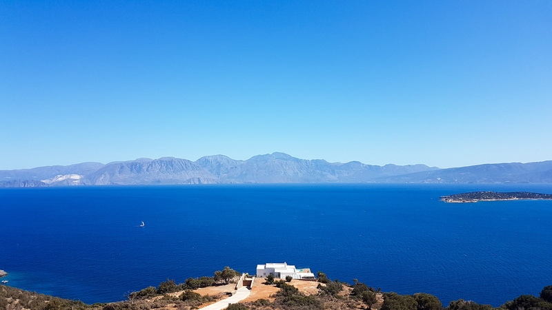 the deep blue water, beauty in nature, house by the sea, copy space, island, land, no people, mountains, tourism, sky, rest, water, sea, clear sky, environment