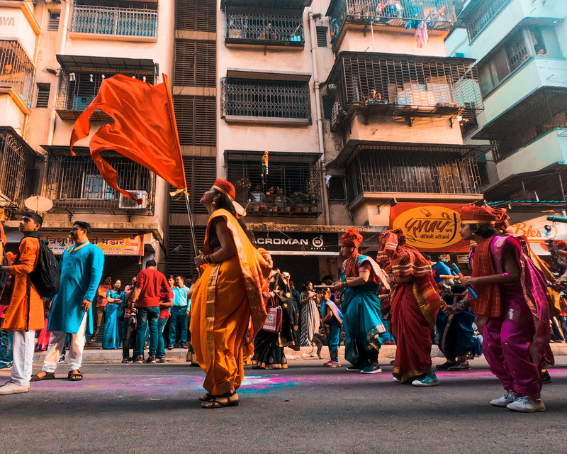 near, festival, building, costume, celebration, colorful, celebrating, city, crowd, low angle shot, dancing, tradition, built structure, action, motion