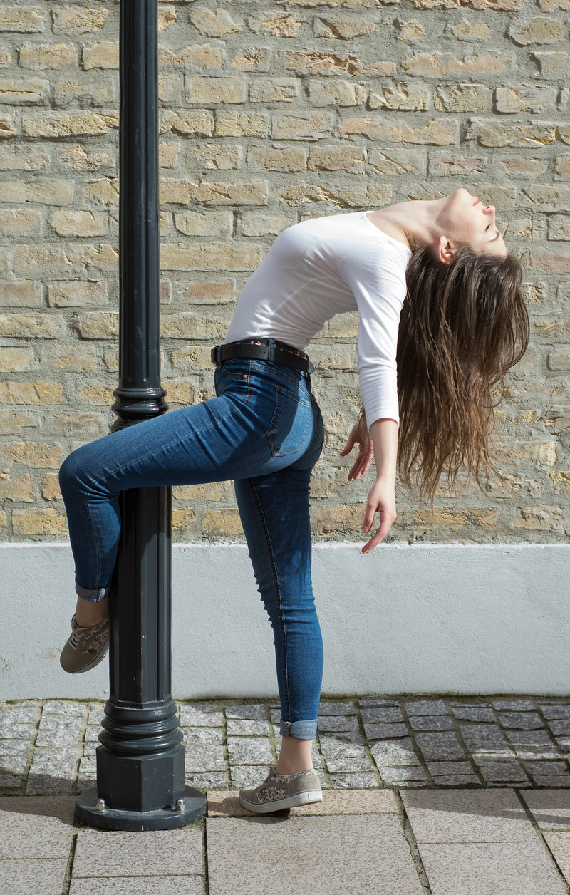 outdoors, wall - building feature, young adult, lifestyles, active, wall, dancer, woman, casual clothing, girl, movement, ballet, jeans, pose, day, bending