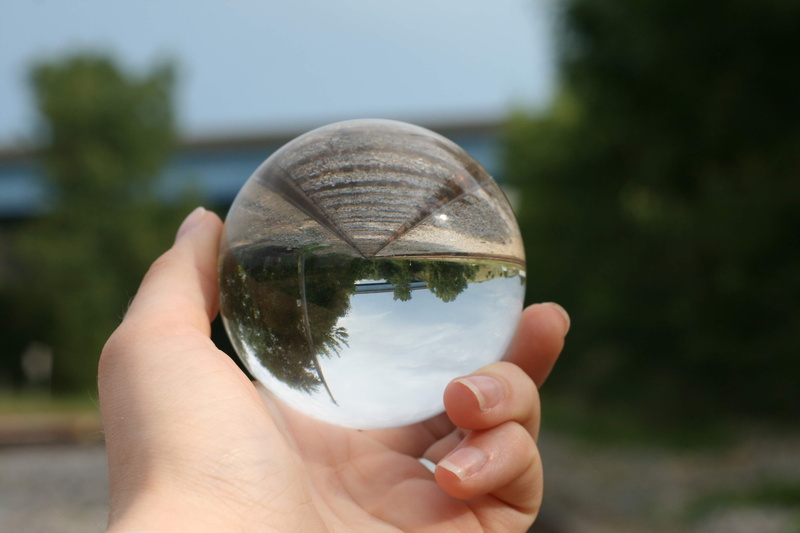 unrecognizable person, real people, holding, crystal ball, close-up, train tracks, sphere, obscured face, photography ball, human hand, body part, hand