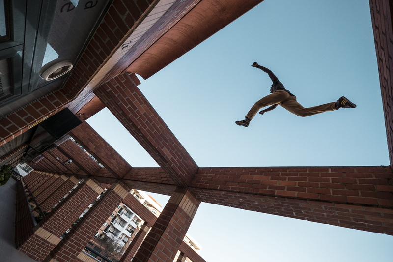 4K, real people, leap, jumping, day, adult, sky, step, built structure, recreation, full length, building, mid-air, motion, low angle view, roof, leisure activity