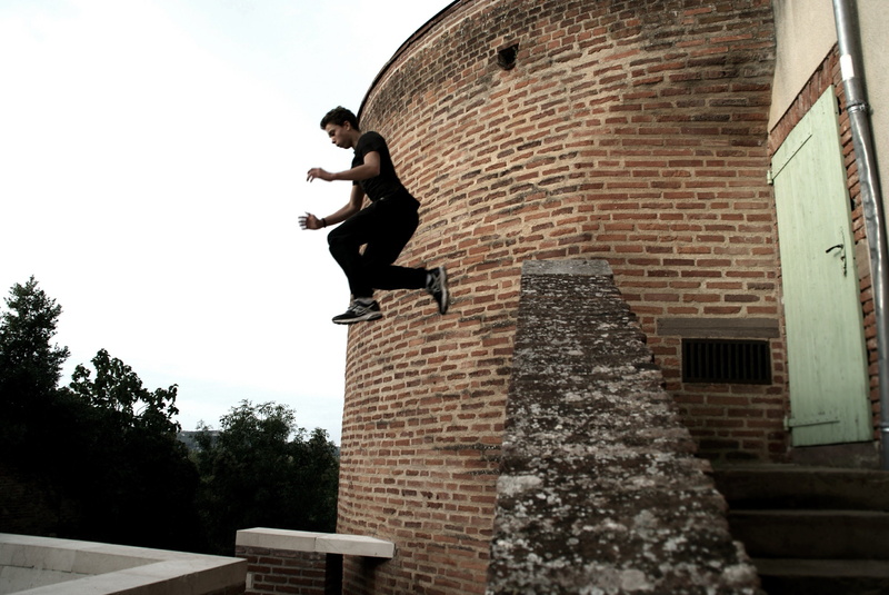 2K, brick wall, outdoors, nature, mid-air, parkour, leisure activity, low angle view, full length, day, one person, architecture, motion, tree, real people