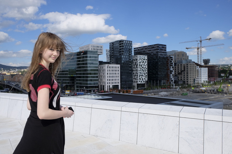 sky, cloud - sky, casual clothing, city, one person, norway, t-shirt, girl, oslo operahouse, standing, day, architecture, buildings, three quarter length