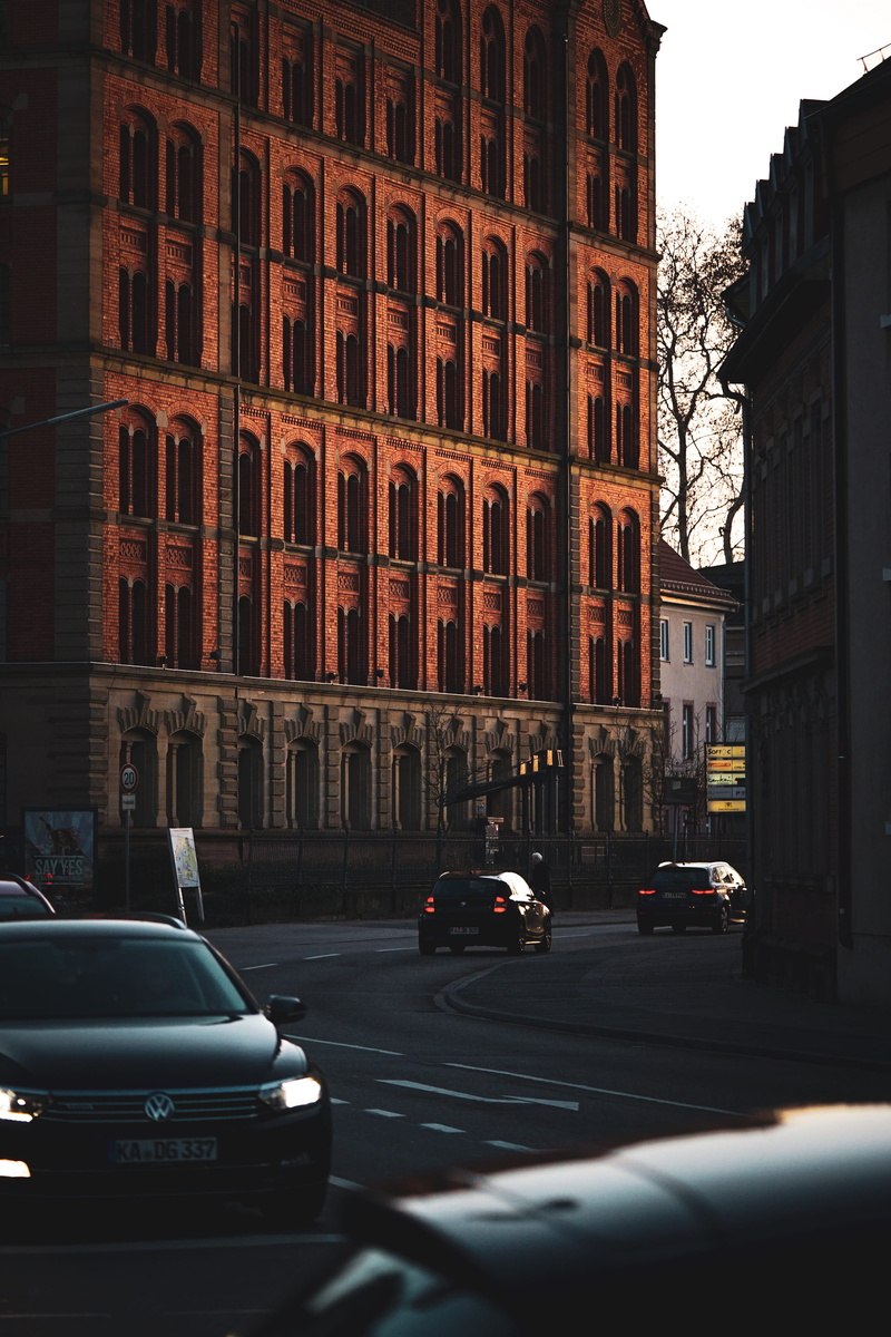 wintersun, buliding, town, transportation, traffic, building, motor vehicle, tall, sports car, busy, built structure, motion, road, cars, mode of transportation