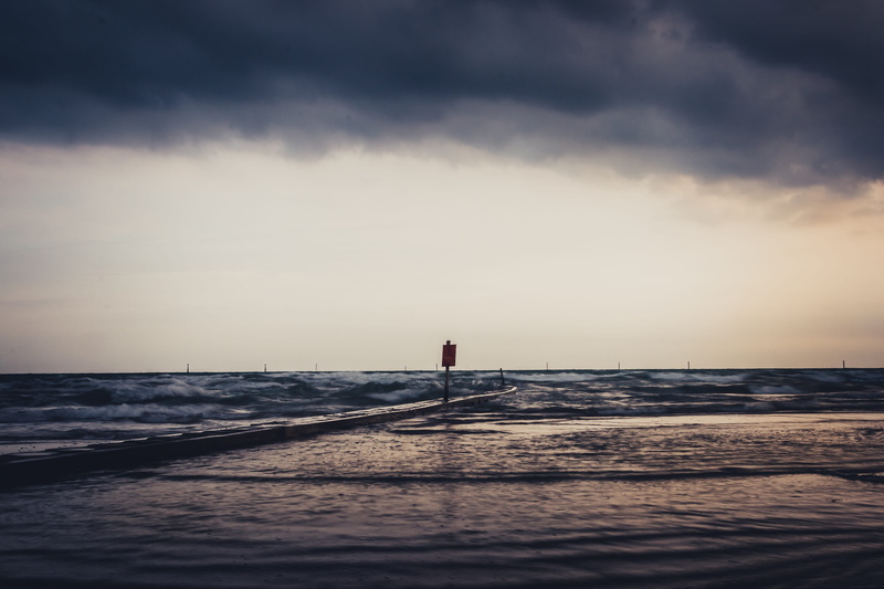 real people, horizon over water, storm, leisure activity, tranquility, vacations, land, ocean, standing, one person, beauty in nature, looking at view