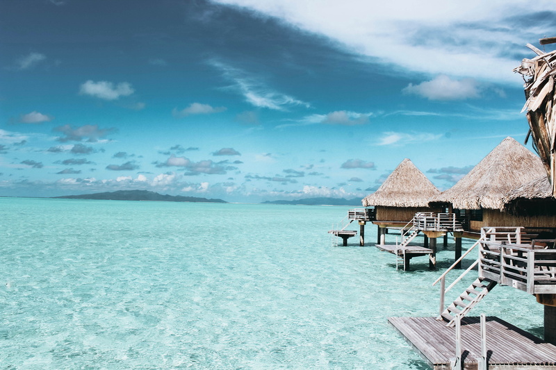 balconies, sea, cloud - sky, ocean, horizon over water, land, day, seashore, resort, thatched roof, chair, sand, cottage, water, wooden, brown, turquoise colored