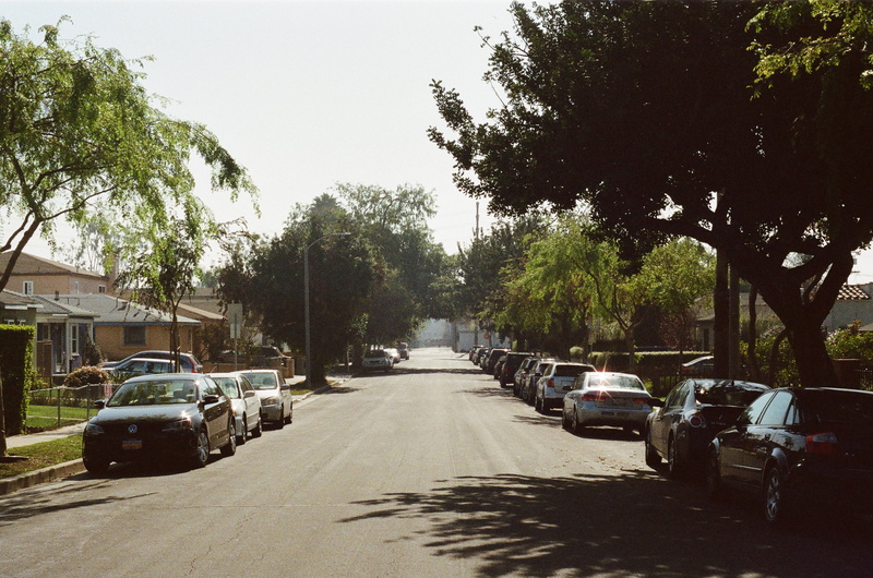 suburbs, car, direction, land vehicle, neighbourhood, parked, residences, houses, city, near, photography, street, plant, trees, transportation, no people