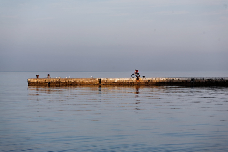 sky, sea, fishing industry, horizon over water, pier, scenics - nature, fishing, waterfront, bicycle, mode of transportation, riding, activity, water, cyclist