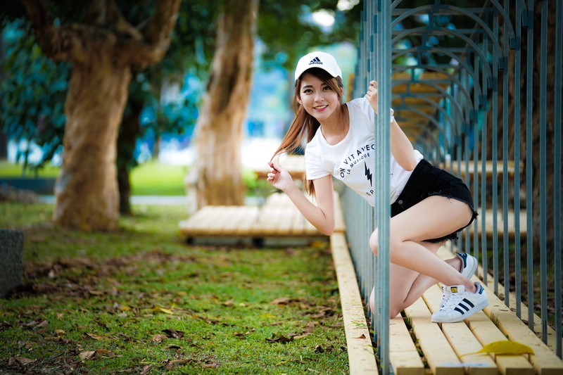 Asian, 2K, depth of field, touching hair, trees, baseball caps, women, brunette, T-shirt, looking at viewer, jean shorts, women outdoors, sneakers, smiling